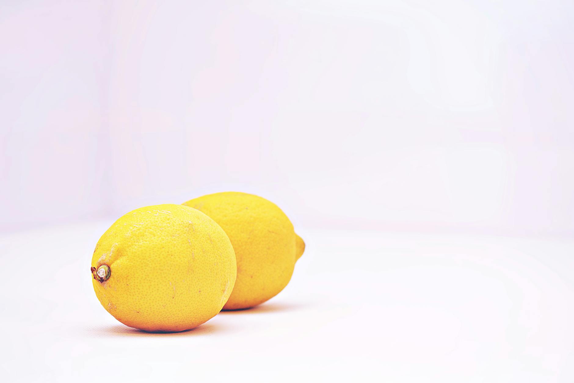 Bright fresh lemons on a soft pastel background, symbolizing renewal and fresh starts