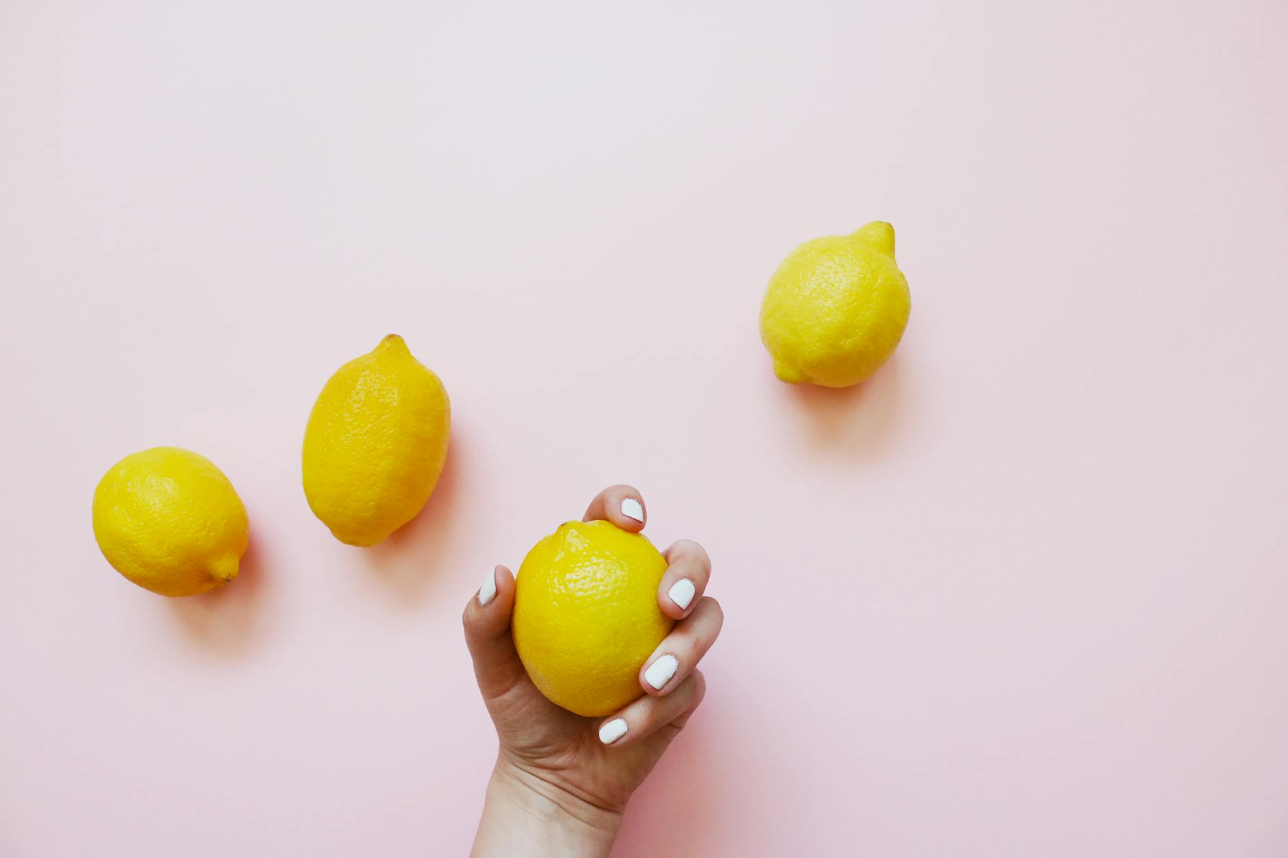 Lemon fruits on soft pink background, symbolizing gentle recovery and fresh starts