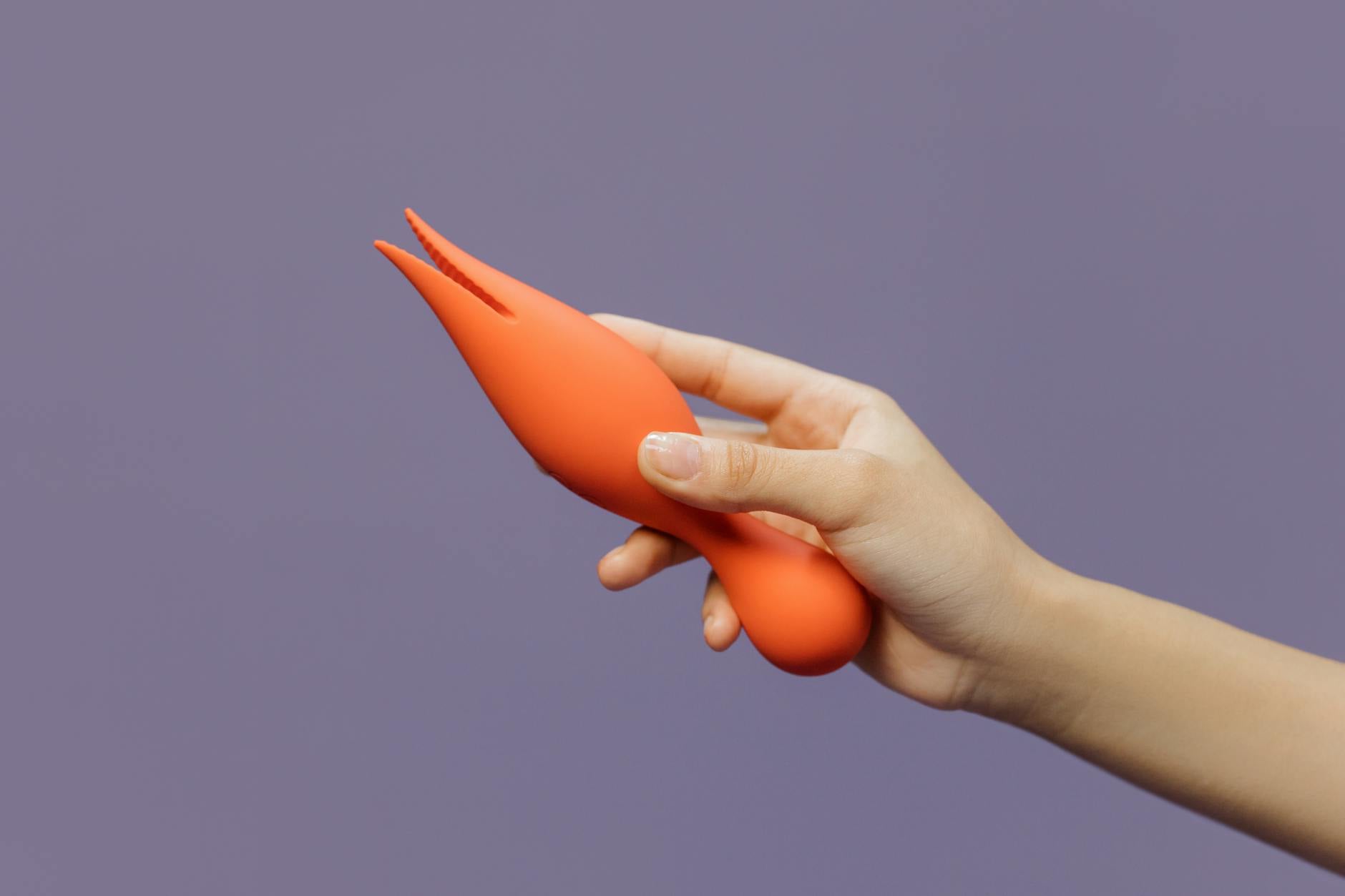 Vibratore in mano contro sfondo viola