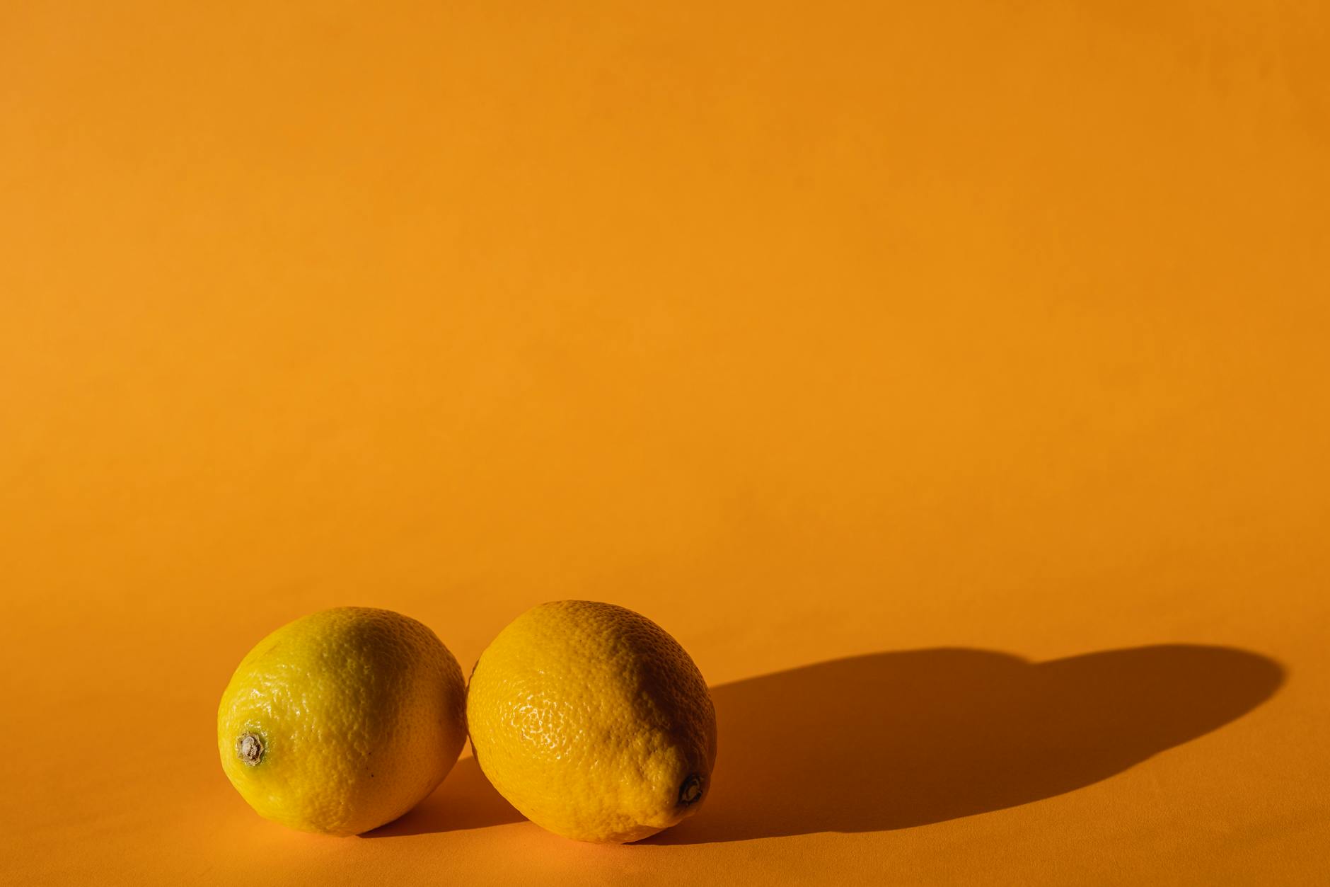 Bright ripe lemons arranged on a yellow background, symbolizing freshness and reclaiming pleasure